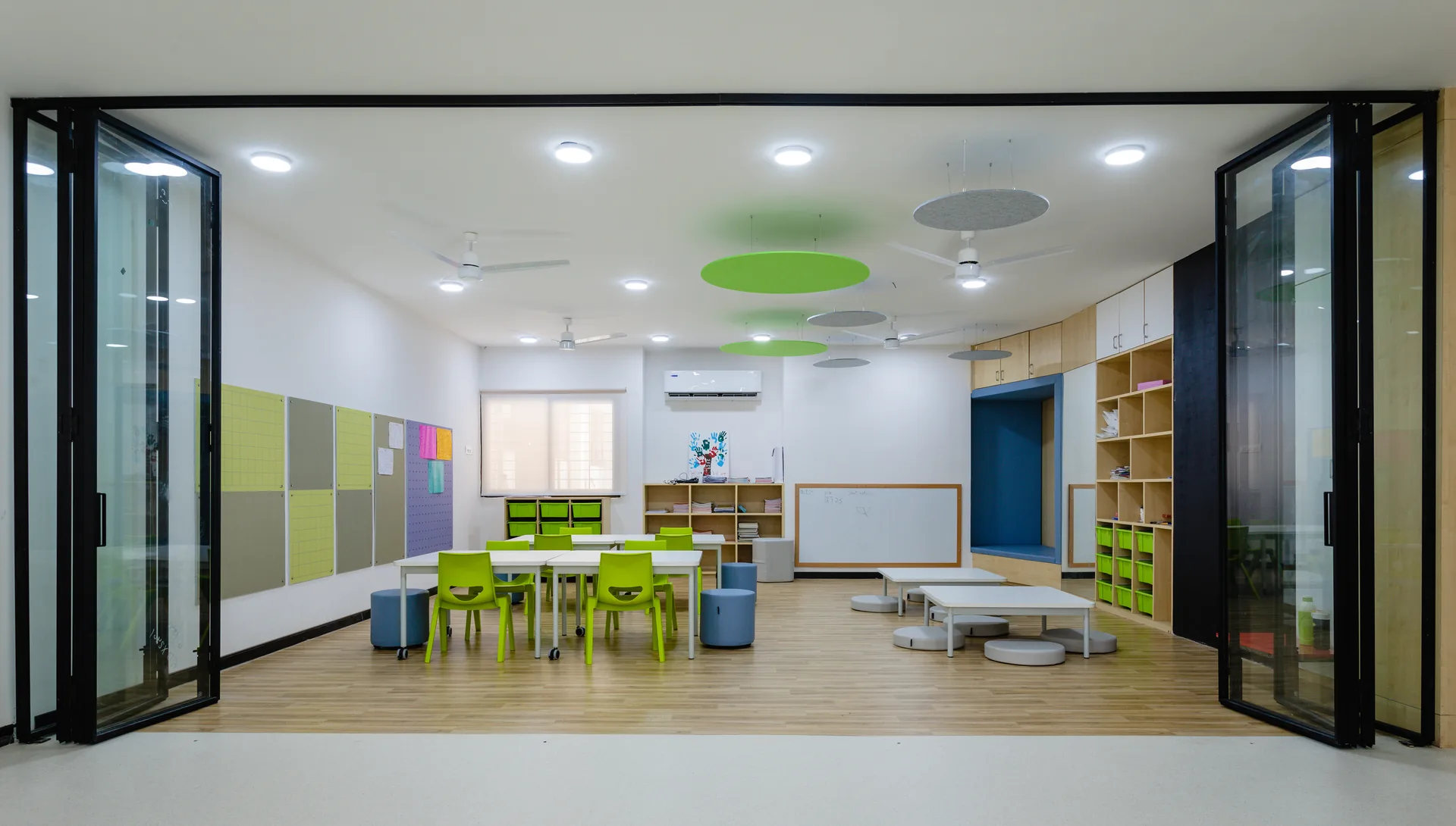 A bright and engaging classroom featuring flexible seating, playful ceiling accents, organized storage, and interactive learning zones, creating a stimulating environment for learning and creativity.