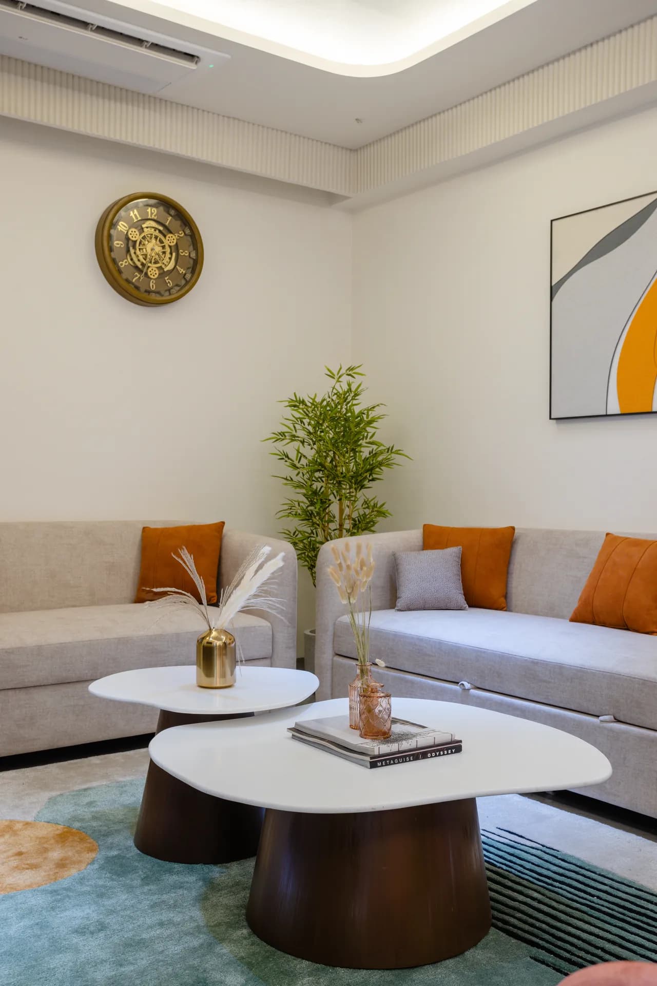 A sophisticated living room featuring soft neutral tones, warm wooden accents, statement artwork, layered lighting, and elegant furniture, creating a refined and welcoming family space.
