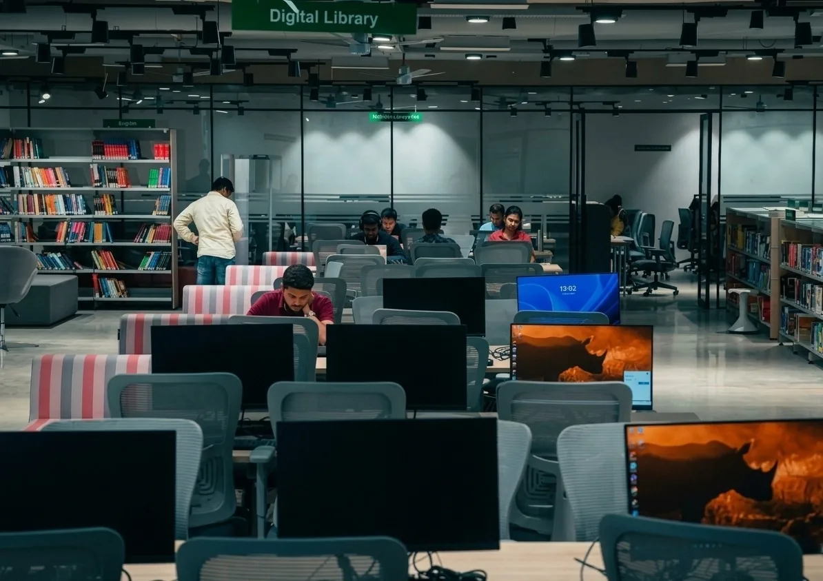 A technology-driven e-library featuring dedicated computer workstations, ergonomic seating, integrated book access, and flexible study zones, creating a connected environment for digital learning and research.