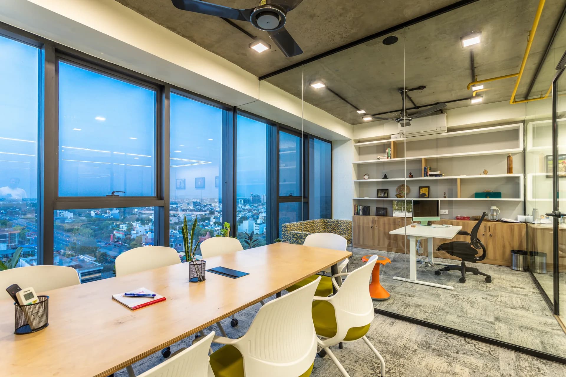 A contemporary meeting cabin featuring panoramic windows, warm wooden finishes, glass partitions, and comfortable seating, creating a bright, collaborative, and visually connected workspace.