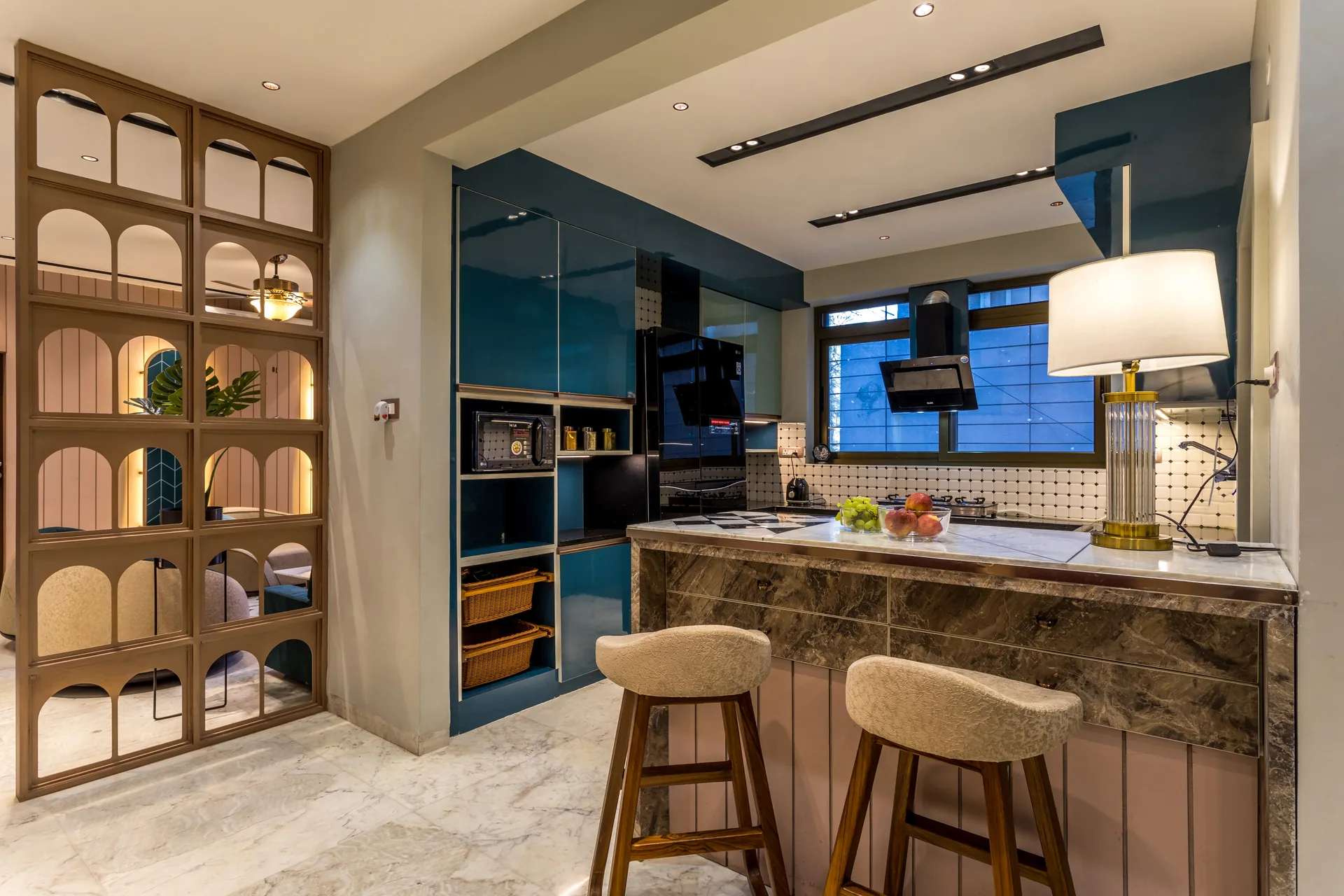 A stylish kitchen and dining space featuring bold teal cabinetry, dark finishes, patterned backsplash, and a functional island, creating a warm and contemporary family setting.